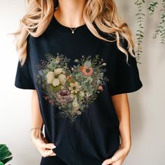 This Floral Heart Graphic Tee made 100% with ring-spun cotton. The soft-washed, garment-dyed fabric brings extra coziness to your wardrobe while the relaxed fit makes it an excellent daily choice. The double-needle stitching throughout the tee makes it highly durable while the lack of side-seams helps the shirt retain its tubular shape. .: 100% ring-spun cotton .: Medium fabric (6.1 oz/yd² (206.8 g/m .: Relaxed fit .: Sewn-in twill label Heart Graphic, Shirts Women Fashion, Floral Heart, Heart Shirt, Shirts Women, Flower Shirt, Dyed Fabric, Floral Shirt, Unisex Shirt