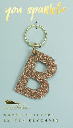 a keychain with the letter b on it is shown in gold and glitter