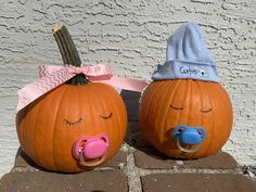 two pumpkins with faces painted to look like babies