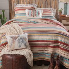 a bed with a wooden headboard and colorful bedspread on top of it