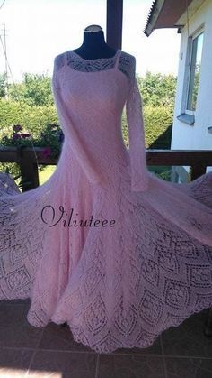 a pink dress is sitting on a mannequin in front of a house with an open window