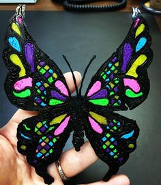 a colorful butterfly is being held in someone's hand