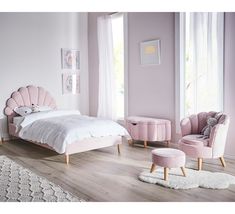 a bedroom with pink walls and furniture in the corner, along with a white rug on the floor