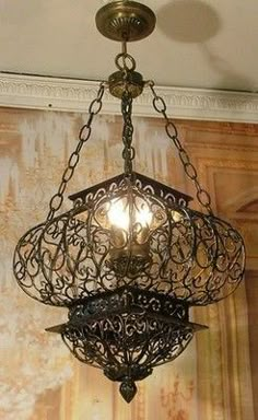 a chandelier hanging from the ceiling with two lights on it's sides