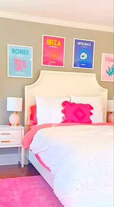 a bedroom with pink carpet and pictures on the wall above the bed, along with two nightstands