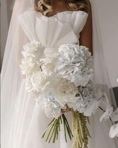 a bride holding a bouquet of white and blue flowers