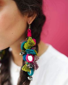 a close up of a person wearing some kind of earring with flowers on it