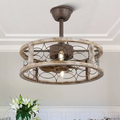 a chandelier hanging from the ceiling in a room with white walls and flowers