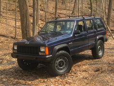 a jeep is parked in the woods by some trees