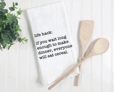 a tea towel with the words calories n on it next to two spoons and a potted plant