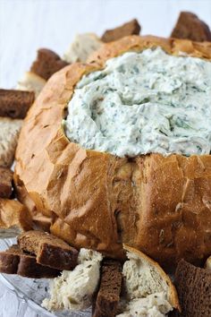 a bread bowl filled with cream cheese and crackers