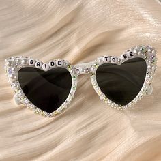 💖💖 Step into the enchanting world of our meticulously crafted heart-shaped sunglasses, where passion meets precision in every detail. Adorned with exquisite pearl embellishments, these sunglasses are a testament to artisanal artistry, perfect for your bridal ensemble. 💍💍 Elevate your bridal style effortlessly with these stunning sunglasses, designed to enhance your special moments. Whether it's your wedding day, honeymoon, bridal shower, or bachelorette party, let these shades add a touch of Groom Sunglasses, Sunglasses Rhinestone, Sunglasses Bride, Sunglasses Wedding, Bride Sunglasses, Bachelorette Veil, Pearl Sunglasses, Wedding Sunglasses, Rhinestone Sunglasses