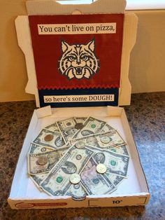 a pizza box with money in it sitting on a counter