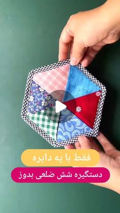 someone is holding an origami piece with different colors and designs on it,