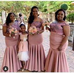 three women in pink dresses standing next to each other and one woman is holding flowers