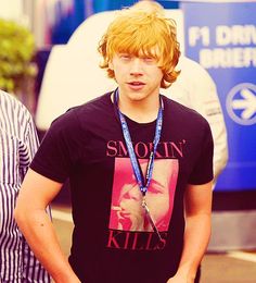 a young man wearing a t - shirt with a lanyard around his neck