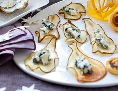 small appetizers are arranged on a plate with purple napkins and star decorations