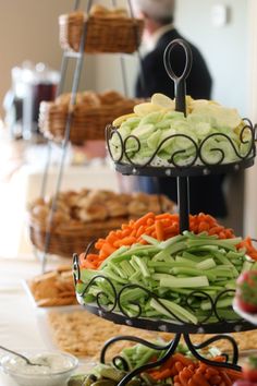 three tiered trays filled with different types of food on top of a table