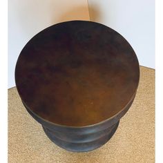 a metal bowl sitting on top of a brown carpeted floor next to a white wall