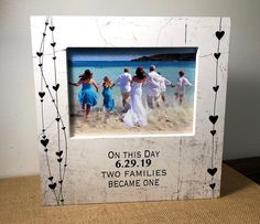 a family picture frame with hearts on the border and an image of four people holding hands