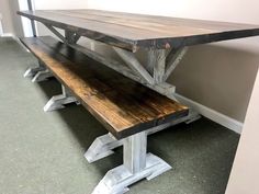 a wooden bench sitting in front of a wall next to a white painted wall and gray carpet