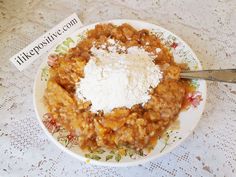 a white plate topped with food next to a spoon