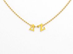 a gold necklace with two letters on it