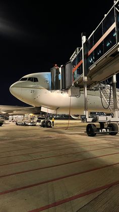 an airplane is parked on the tarmac at night