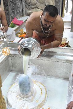 a man is washing his hands in the water from a faucet at a temple