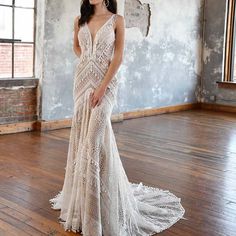 a woman standing in an empty room wearing a white wedding dress with open back and crochet detailing