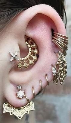 an ear with several different types of piercings