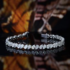 This 9.00 carat brilliant pear cut diamond tennis bracelet have a remarkable 100% eye-clean VS2 clarity grading and G color grading (very white) where these diamond stones glitters and sparkles perfectly. It is a magnificent prong setting that stretches to 7.5 inches long (other length available by request). Metal : 14K Gold or 18K Gold Setting Type : Prong Total Carat Weight : 9.00 Carats Type : Natural Shape : Pear Cut Carat Weight : 9.00 Ct. Cut : Excellent Color : G (White) Clarity : VS2 (10 Pear Shape Diamond Bracelet, Pear Shaped Tennis Bracelet, Unique Gold Jewelry Designs, Bracelet Diamond, Diamond Jewelry Necklace, Pear Cut Diamond, Diamond Tennis Bracelet, Color Grading, Diamond Bangle