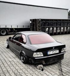 a car that is sitting on the ground next to a truck