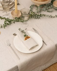 the table is set with plates, silverware and napkins for an elegant dinner