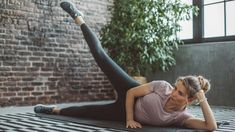 a woman in black leggings is laying on the floor