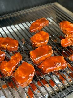 several pieces of meat cooking on a grill with sauces over the bbq grates