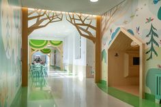 the interior of a children's playroom with trees painted on the walls and floor