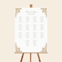 an easel with a wedding seating chart on it, and the wording is gold