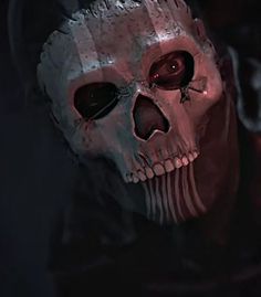 a creepy looking skull with red eyes in the dark