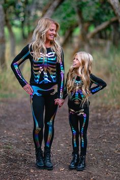 mother and daughter wearing skeleton bodysuits in the woods