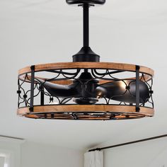 a ceiling fan that is hanging from the ceiling in a room with white walls and windows