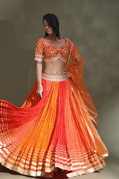 Dance the night away at weddings in this stunning orange and red lehenga with gota border and embroidered choli. It comes with a matching dupatta. Shop designer lehenga in USA from Pure Elegance. Orange Sharara With Sheer Dupatta For Diwali, Orange Sharara With Sheer Dupatta For Navratri, Orange Sharara With Resham Embroidery For Navratri, Orange Bollywood Sets With Cutdana Details, Orange Bollywood Cutdana Sets, Orange Anarkali Choli In Chanderi Fabric, Orange Sets With Sheer Dupatta For Navratri, Orange Semi-stitched Anarkali Set For Navratri, Semi-stitched Orange Anarkali Set For Navratri