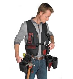 a man holding tools in his hands while wearing an overall and carrying a tool belt