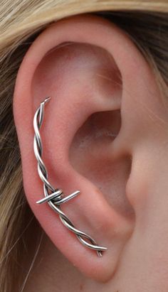 a woman's ear is shown with two silver wires attached to it