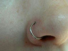 a close up view of a nose with a curved nose ring on it's side