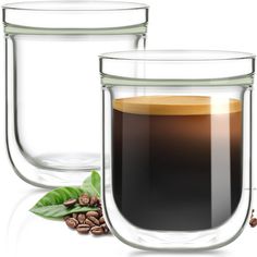 two glass mugs filled with liquid and coffee beans