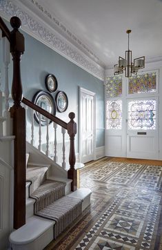 the stairs in this house are decorated with decorative tiles and glass windows, along with round mirrors