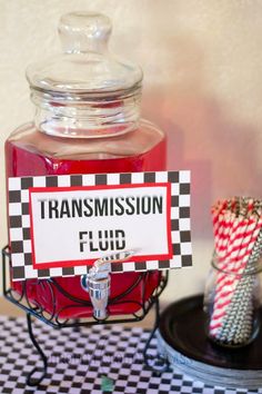 a glass jar filled with liquid sitting on top of a black and white checkered table cloth