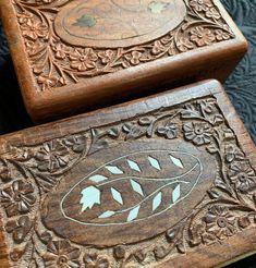 two wooden boxes with carved designs on them