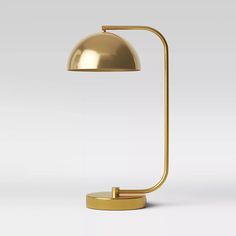 a gold lamp on a white background with the light turned off to show its dim lighting